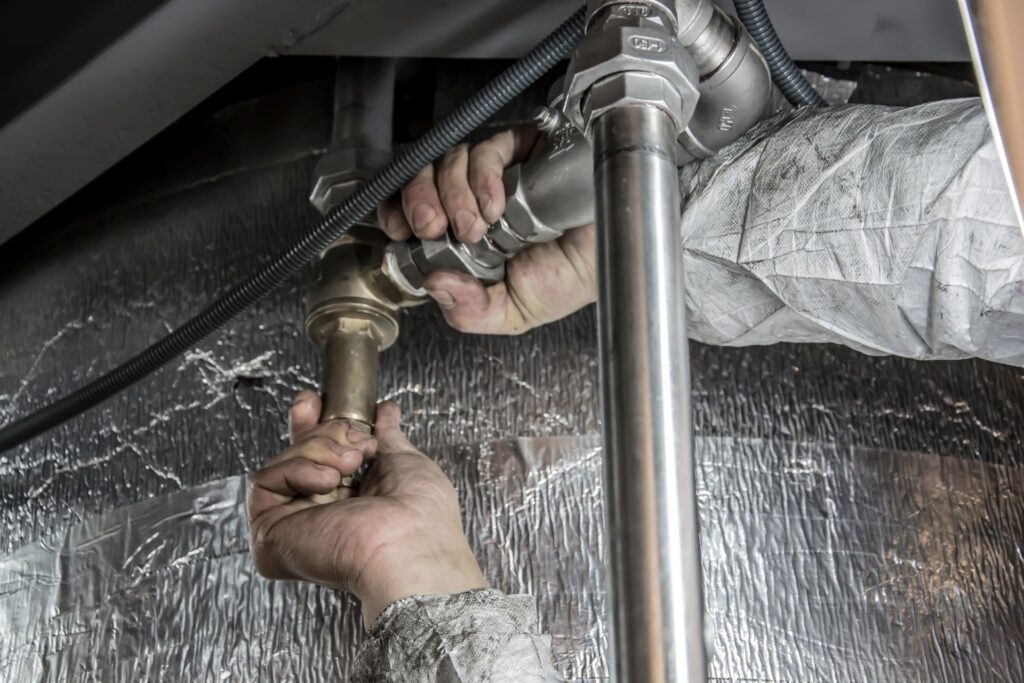 Installateur montiert Rohrleitungen aus Stahl