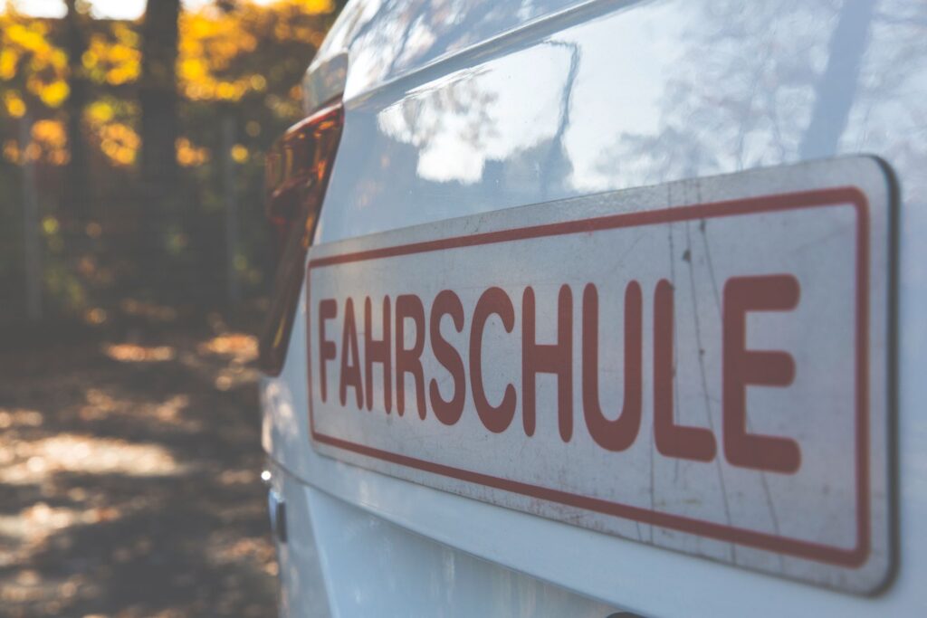 Fahrschulauto mit Dachschild am Straßenrand
