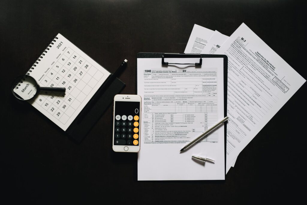 Steuerformulare, Taschenrechner und Kalender auf einem Schreibtisch